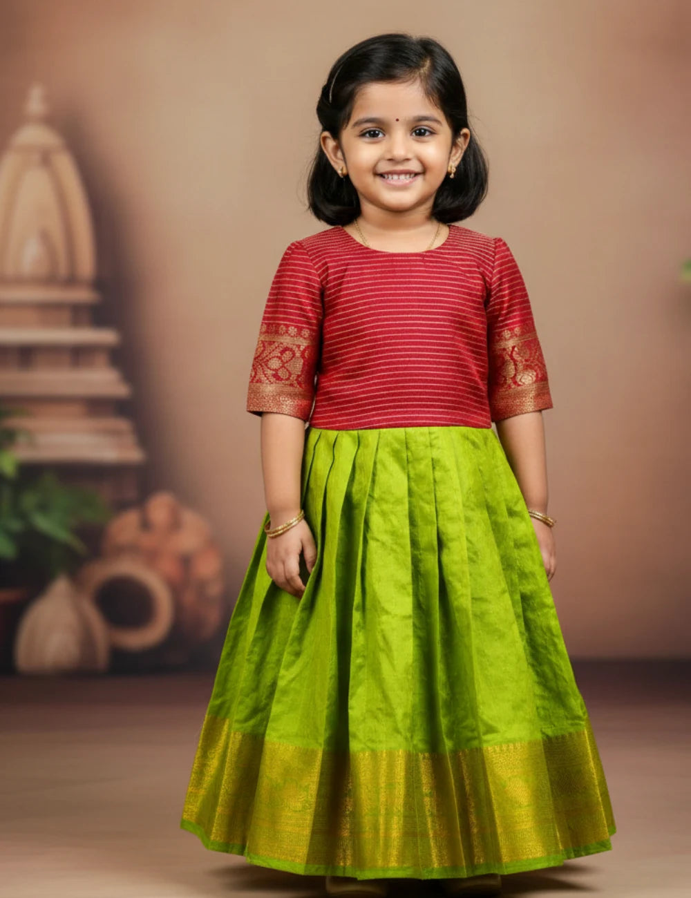 Child wearing a red top and green skirt with gold accents against a brown background