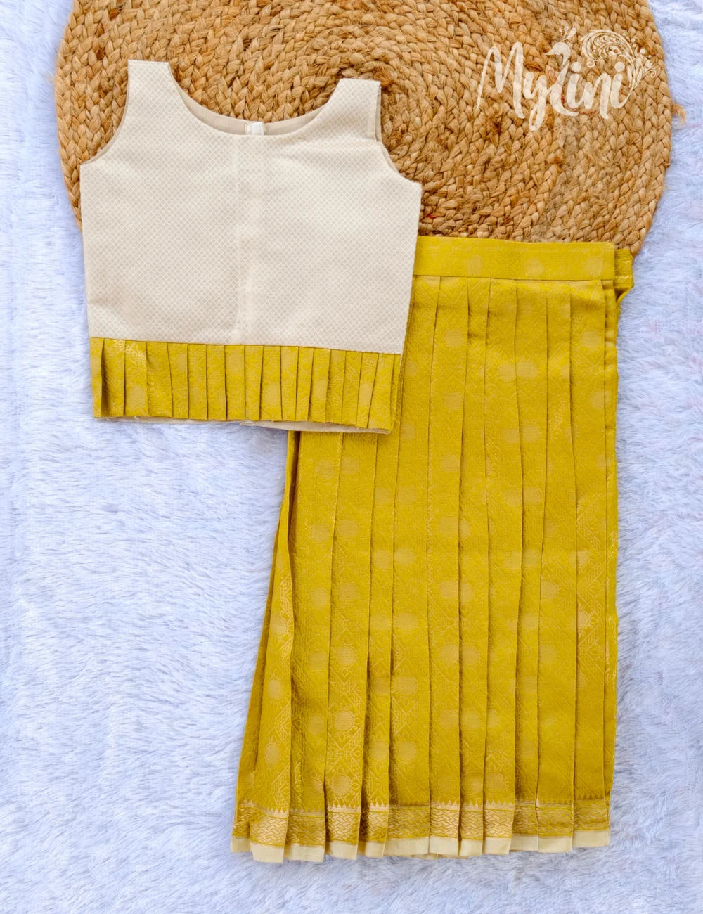 Young girl in a yellow and white traditional outfit standing in a decorated room.