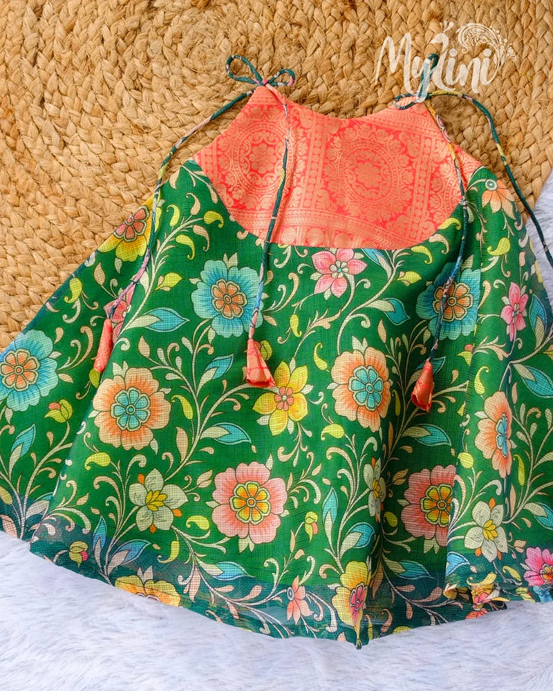 Colorful floral baby dress with a red top on a textured surface
