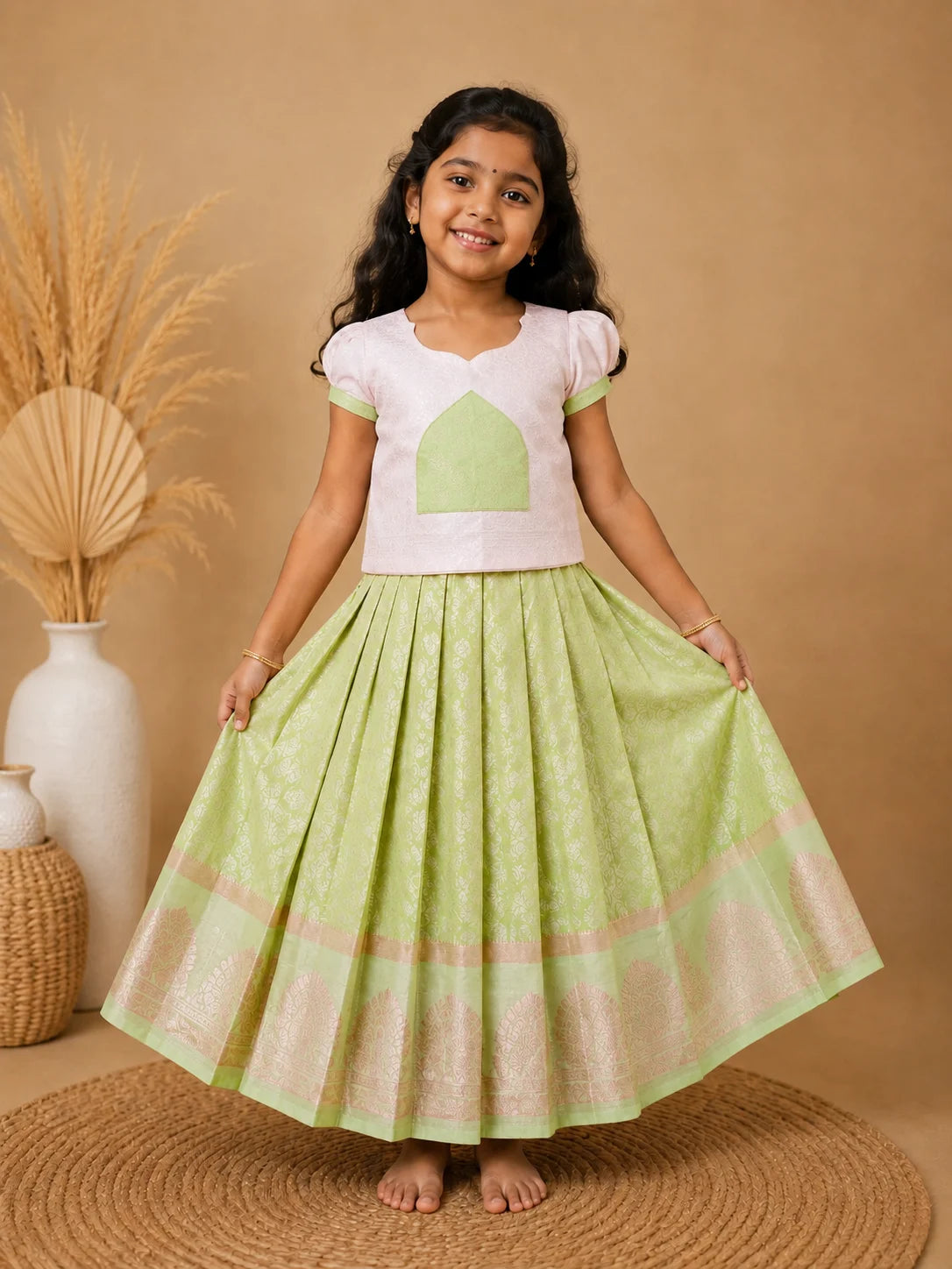 Young girl wearing a white top with green accents and a green skirt on a beige background