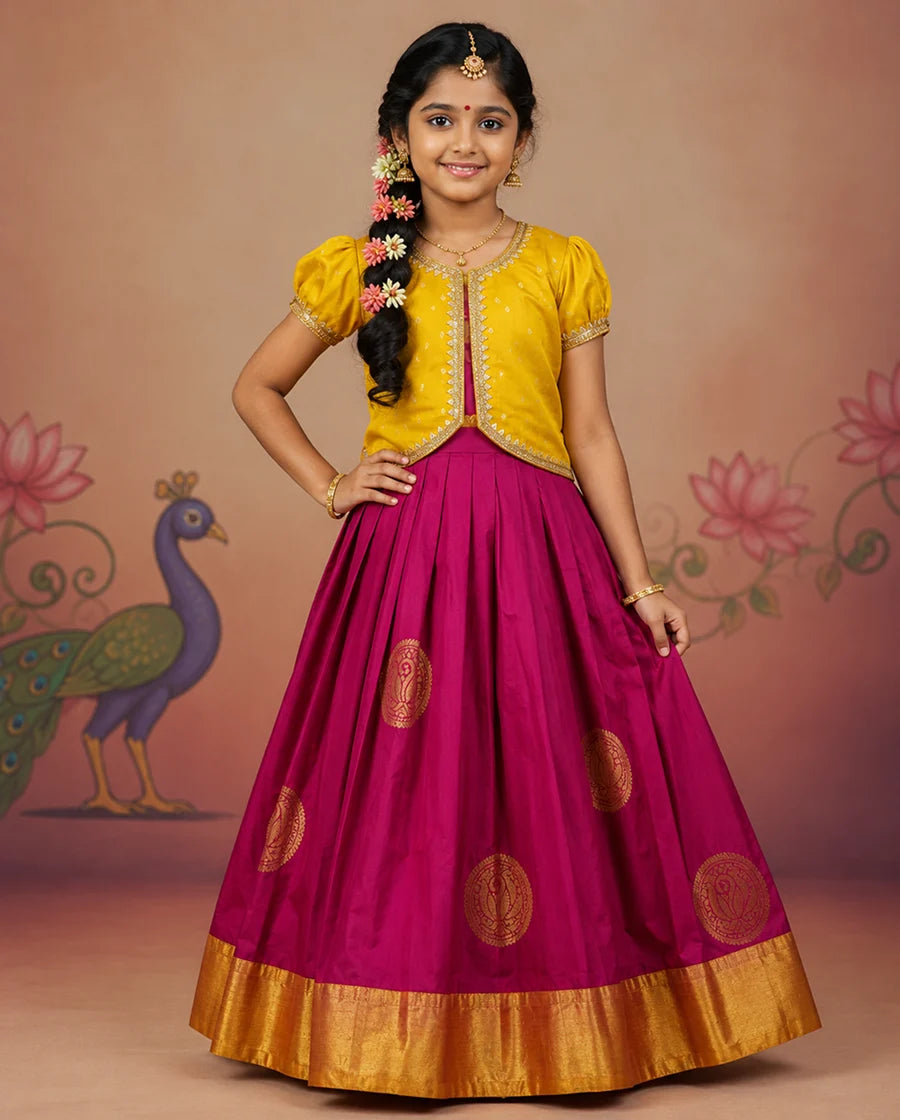Young girl in a yellow top and pink skirt with gold details against a decorative background.