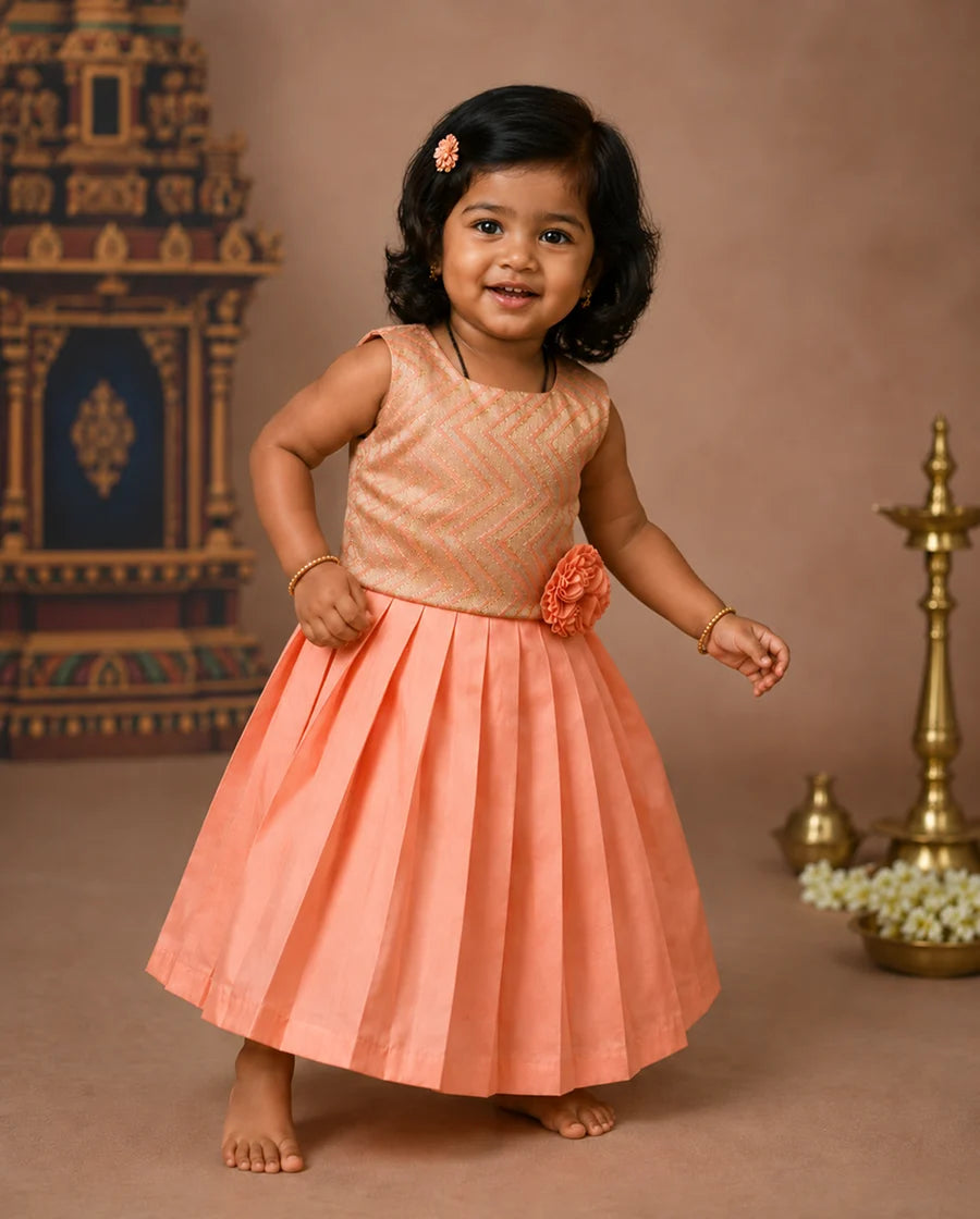 Young girl in a peach dress with floral details against a decorative background