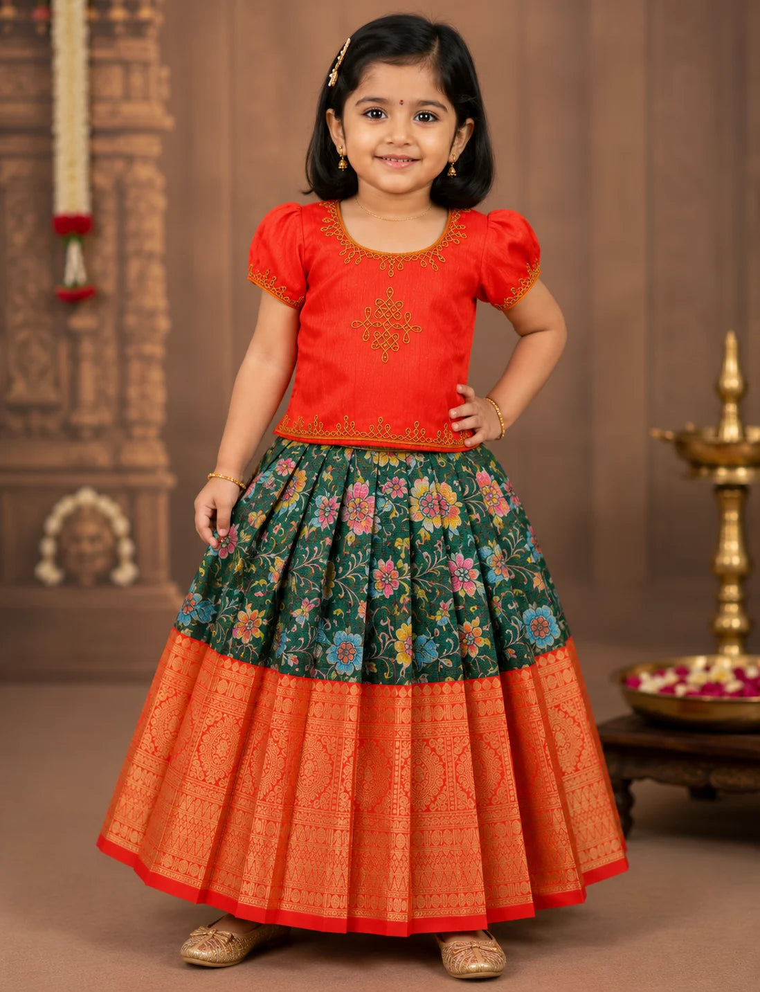 Young girl wearing a traditional outfit with a red top and colorful skirt against a decorative background.