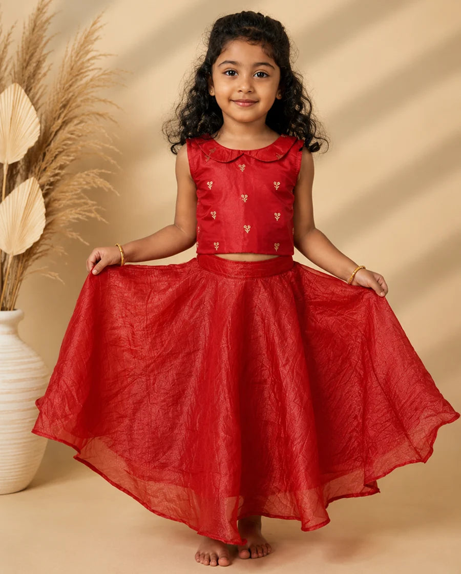 Young girl wearing a red traditional outfit with a beige background