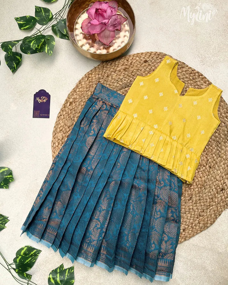 Child wearing a yellow top and blue skirt in a decorated indoor setting