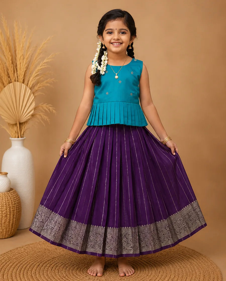 Young girl in a blue top and purple skirt standing on a brown floor with decorative elements.