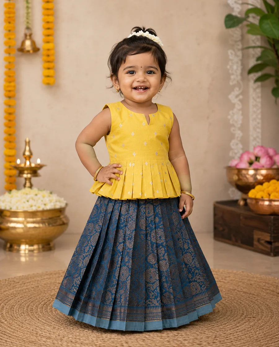 Child wearing a yellow top and blue skirt in a decorated indoor setting
