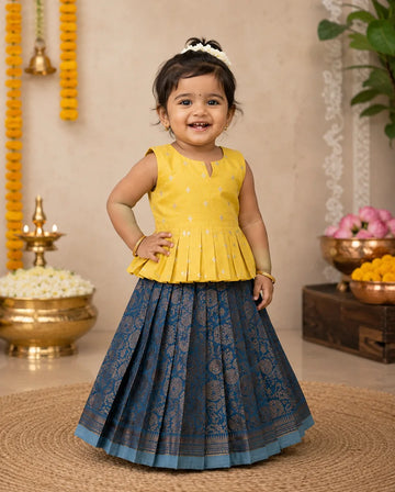 Child wearing a yellow top and blue skirt in a decorated indoor setting