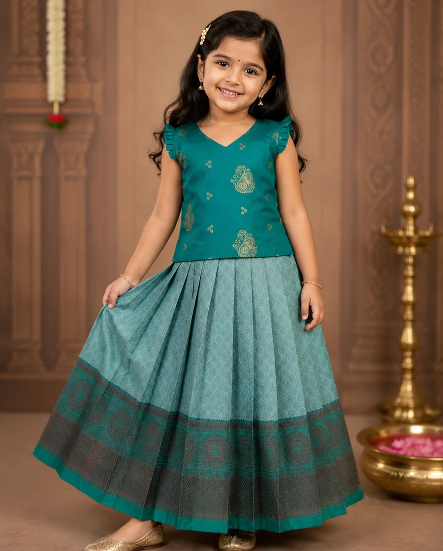 Young girl in a teal traditional outfit with a decorative background